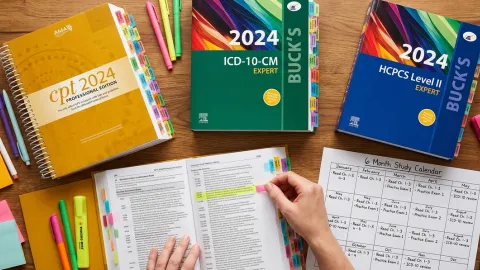 CPC exam study setup with color-tabbed medical coding books and handwritten study schedule